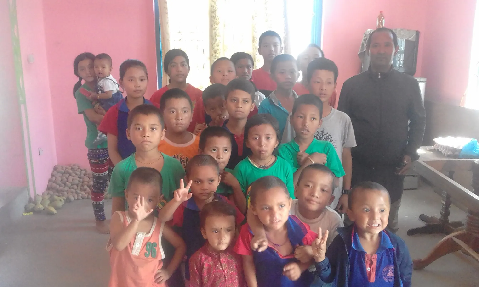 Children crowded together smiling in the dining room