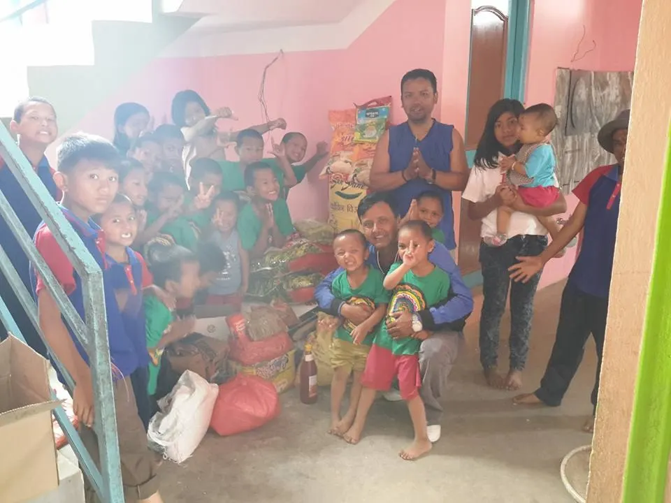 Children gathered indoors as gifts and clothes are handed out