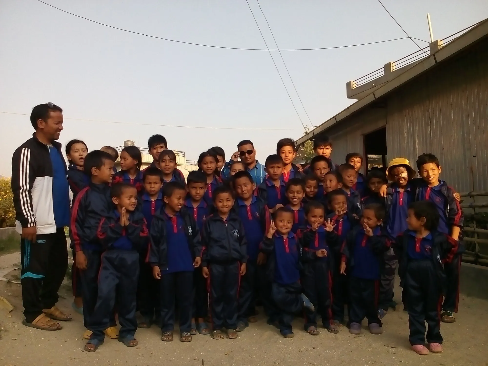 The children of Yamuna Children's Home gathered outside with their house parents in the evening light