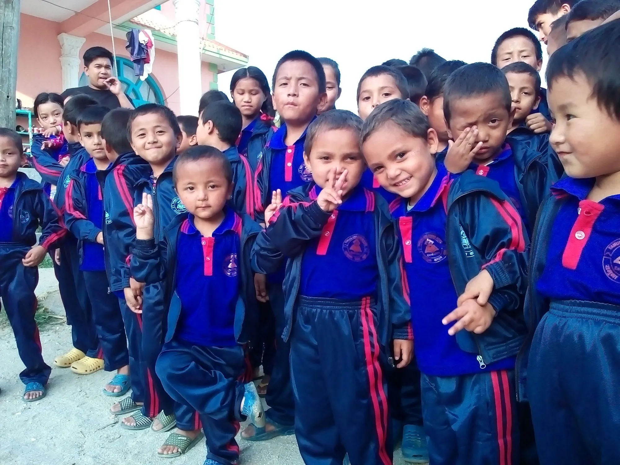 A group of children making peace signs and laughing