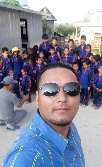 Serki Sherpa photographed with the children of the home behind him