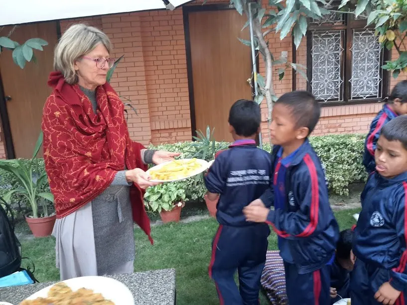 Heike Yamuna Kiefer serving food to children in a garden